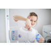 Housework: young woman doing laundry - putting colorful garments into the washing machine (shallow DOF; color toned image)