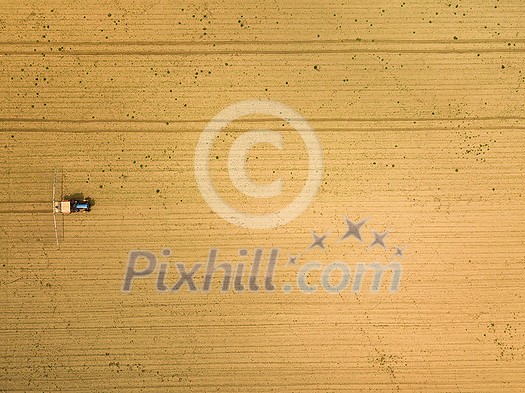 Tractor spraying crops in field, aerial view from drone pov Tractor spraying crops in field, aerial view from drone pov