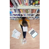 student taking notes from a book at library. Young woman sittingin in school library and working with laptop