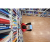 top view of a young student with glasses sits in the library, reads a book and makes notes with a latpop