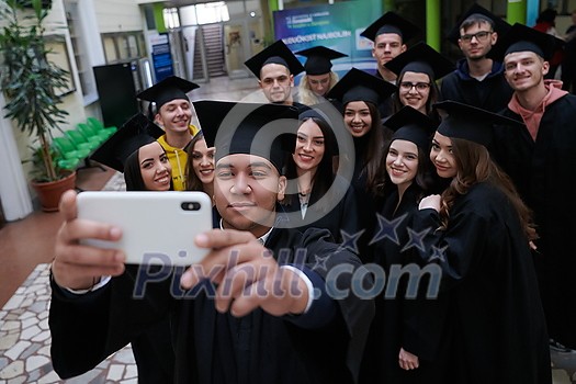 education, graduation, technology and people concept - group of happy international students in mortar boards and bachelor gowns with diplomas taking selfie by smartphone education, graduation, technology and people concept - group of happy international students in mortar boards and bachelor gowns with diplomas taking selfie by smartphone