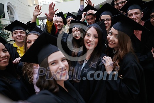 education, graduation, technology and people concept - group of happy international students in mortar boards and bachelor gowns with diplomas taking selfie by smartphone education, graduation, technology and people concept - group of happy international students in mortar boards and bachelor gowns with diplomas taking selfie by smartphone