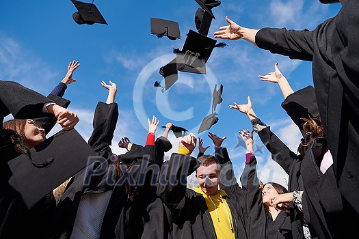 Congratulations! Low angle view of happy group of six young cheerful graduates in black gowns, throwing up their head wear in the air and celebrating, in blue summer sky, laughing, enjoying Congratulations! Low angle view of happy group of six young cheerful graduates in black gowns, throwing up their head wear in the air and celebrating, in blue summer sky, laughing, enjoying