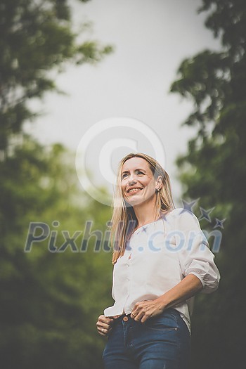 Portrait of a relaxed middle aged woman outdoors, looking happy, enjoying the life Portrait of a relaxed middle aged woman outdoors, looking happy, enjoying the life