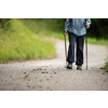 Senior person staying fit by doing daily cardio exercise, going for a fast paced power walk with sticks