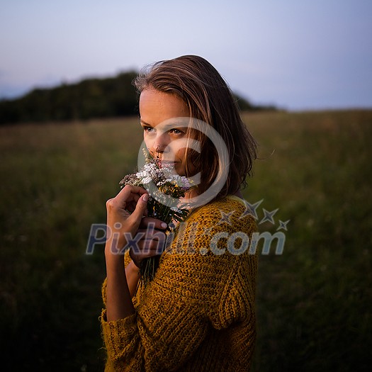 Beautiful young woman outdoors with a bouquet of wild flowers in a field, enjoying nature. Happy Woman on spring meadow Beautiful young woman outdoors with a bouquet of wild flowers in a field, enjoying nature. Happy Woman on spring meadow