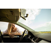 Pretty middle aged woman at the steering wheel of her car