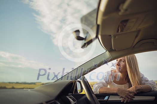Pretty middle aged woman at the steering wheel of her car Pretty middle aged woman at the steering wheel of her car