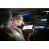 Young female driver playing with her cellphone instead of paying attention to driving startled in a potentially dangerous situation - Road safety concept