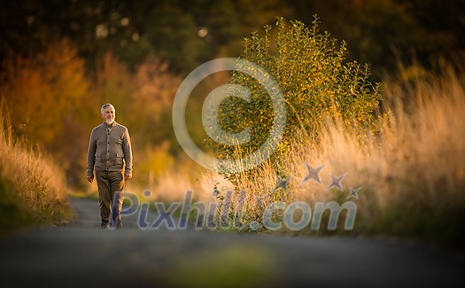 Portrait of handsome senior man in the autumn outdoors. Active senioor enjoying his retirement in the nature Portrait of handsome senior man in the autumn outdoors. Active senioor enjoying his retirement in the nature