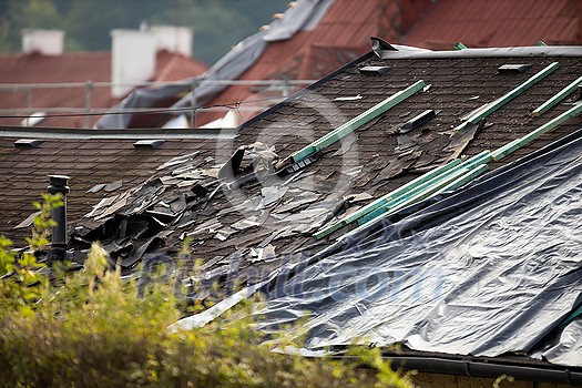 Storm damaged roof, destroyed roof tiles, expensive damage needing prompt repair Storm damaged roof, destroyed roof tiles, expensive damage needing prompt repair