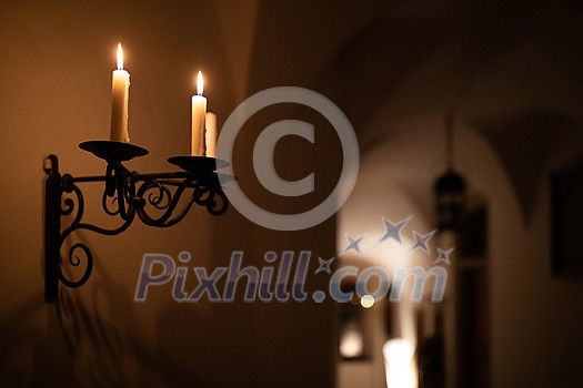 Splendid chandelier with lit candles in a beautiful room of an old mansion Splendid chandelier with lit candles in a beautiful room of an old mansion