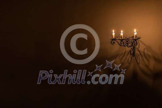 Splendid chandelier with lit candles in a beautiful room of an old mansion Splendid chandelier with lit candles in a beautiful room of an old mansion