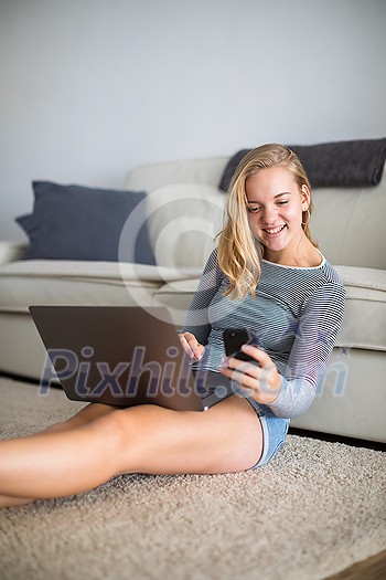 Teenage girl using her smart phone and laptop computer (shalllow DOF, color toned image) Teenage girl using her smart phone and laptop computer (shalllow DOF, color toned image)