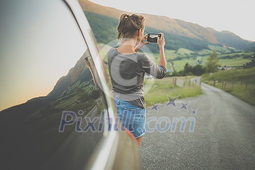Traveling in nature, woman photographing alpine landscape with her smartphone Traveling in nature, woman photographing alpine landscape with her smartphone