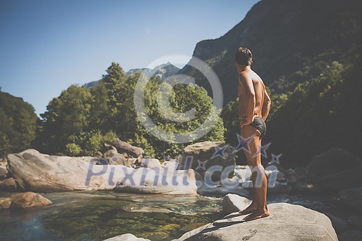 Turquoise waters of Verzasca river near Lavertezzo, Ticino, Switzerland - young man going for a swim Turquoise waters of Verzasca river near Lavertezzo, Ticino, Switzerland - young man going for a swim