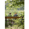 Elderly couple outdoors in summer. Happy elderly couple on a walk. Handsome man and woman senior citizens. Husband and wife of old age against the background of nature.