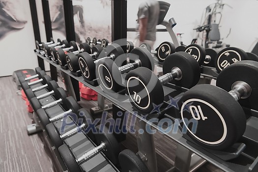 Closeup of kilogram dumbbells placed on a dumbbell rack at the gym. Weight training equipment. High-quality photo Closeup of kilogram dumbbells placed on a dumbbell rack at the gym. Weight training equipment. High-quality photo