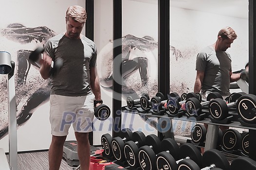 Struggling with age. Confident senior man exercising with dumbbells in the health club. Selective focus. High-quality photo Struggling with age. Confident senior man exercising with dumbbells in the health club. Selective focus. High-quality photo