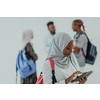 African female student with a group of friends in the background wearing traditional Islamic hijab clothes. Selective focus. High-quality photo