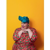 Funny plus size sexy model woman with trendy makeup, fashionable overweight blonde in colorful dress posing at the yellow background in studio. High quality photo