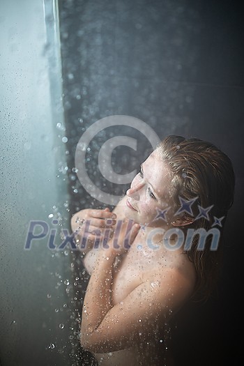 Pretty,young woman taking a long hot shower in a modern bathroom Pretty,young woman taking a long hot shower in a modern bathroom