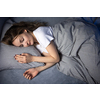 Pretty, young woman sleeping in her bed late in the morning on a weekend - compensating for the lack of sleep