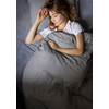 Pretty, young woman sleeping in her bed late in the morning on a weekend - compensating for the lack of sleep