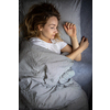 Pretty, young woman sleeping in her bed late in the morning on a weekend - compensating for the lack of sleep