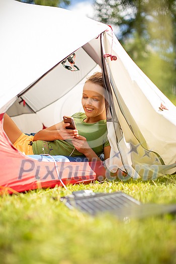 Cell phone charging with a solar charger in a tent during an outdoor trip Cell phone charging with a solar charger in a tent during an outdoor trip