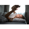 Pretty, young woman sleeping in her bed with her cell phone close to her. Smartphone in Bed Mobile/smartphone  Addiction Concept.