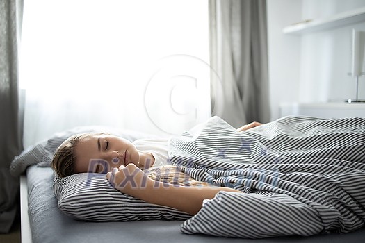 Pretty, young woman sleeping in her bed with her cell phone close to her. Smartphone in Bed Mobile/smartphone Addiction Concept. Pretty, young woman sleeping in her bed with her cell phone close to her. Smartphone in Bed Mobile/smartphone Addiction Concept.