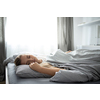 Pretty, young woman sleeping in her bed with her cell phone close to her. Smartphone in Bed Mobile/smartphone  Addiction Concept.