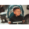 Sweet baby boy tow years old in a stroller bicycle outdoors. Little child in a pram. Infant kid in a pushchair. Spring walks with kids. High quality photo