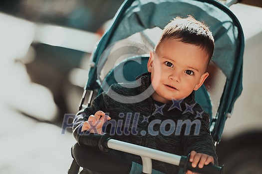 Sweet baby boy tow years old in a stroller bicycle outdoors. Little child in a pram. Infant kid in a pushchair. Spring walks with kids. High quality photo Sweet baby boy tow years old in a stroller bicycle outdoors. Little child in a pram. Infant kid in a pushchair. Spring walks with kids. High quality photo