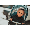 Sweet baby boy tow years old in a stroller bicycle outdoors. Little child in a pram. Infant kid in a pushchair. Spring walks with kids. High quality photo