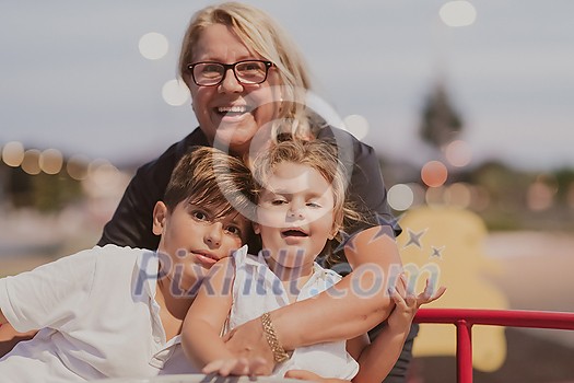 An older grandmother is playing with her grandchildren in a park at sunset. Selective focus. High-quality photo An older grandmother is playing with her grandchildren in a park at sunset. Selective focus. High-quality photo
