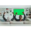 African Couple Sitting On Sofa Watching TV Together Chroma Green Screen Woman Wearing Islamic Hijab Clothes. High quality photo