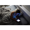 Pretty, middle-aged woman using her tablet computer before sleep in bed in the evening