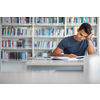 Students in a library - handsome student reading a book for his class in a bright modern library