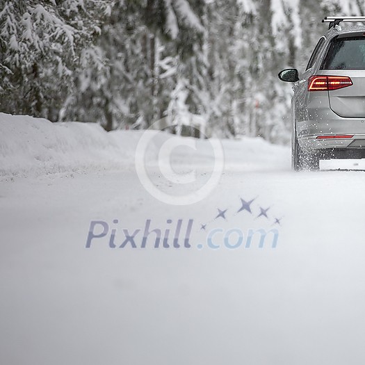 Car on a snowy winter road amid forests - using its four wheel drive capacities to get through the snow Car on a snowy winter road amid forests - using its four wheel drive capacities to get through the snow