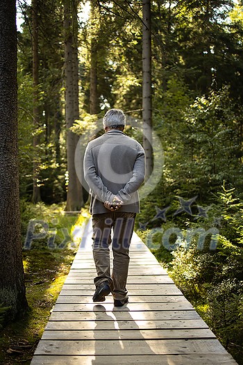 Senior man enjoying the outdoors, hiking, walking throught lovely nature Senior man enjoying the outdoors, hiking, walking throught lovely nature