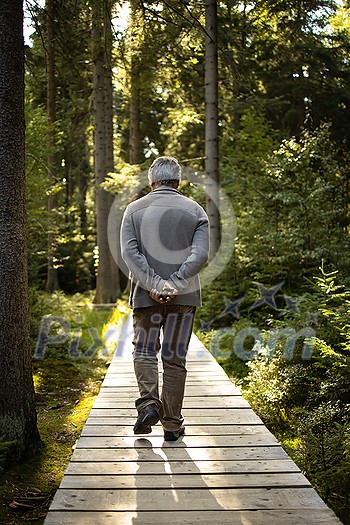 Senior man enjoying the outdoors, hiking, walking throught lovely nature