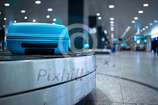 Arrived luggage going around on a conveyor belt waiting to be claimed at the baggage claim zone at a modern international airport Arrived luggage going around on a conveyor belt waiting to be claimed at the baggage claim zone at a modern international airport