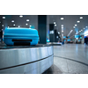 Arrived luggage going around on a conveyor belt waiting to be claimed at the baggage claim zone at a modern international airport