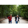 Active handsome senior walking, hiking outdoors on a forest path, enjoying his retirement with his daughter
