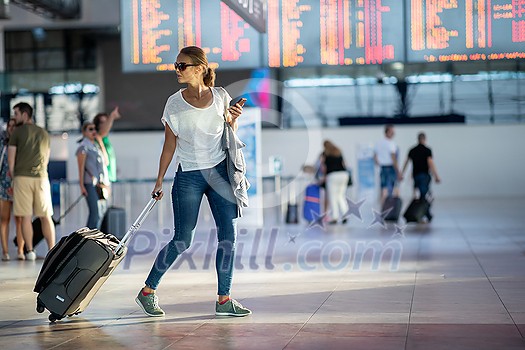 Young woman with her luggage at an international airport, before going through the check-in and the security check before her flight Young woman with her luggage at an international airport, before going through the check-in and the security check before her flight