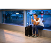 Young woman with her luggage at an international airport, before going through the check-in and the security check before her flight