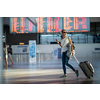 Young woman with her luggage at an international airport, before going through the check-in and the security check before her flight