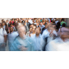 Crowd of people walking on city street - motion blurred image with unrecognizable faces - Young woman standing still, feeling down, depressed